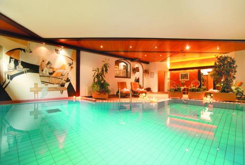 ein großer Pool in einem großen Haus in der Unterkunft Hotel Tschurtschenthaler in Toblach