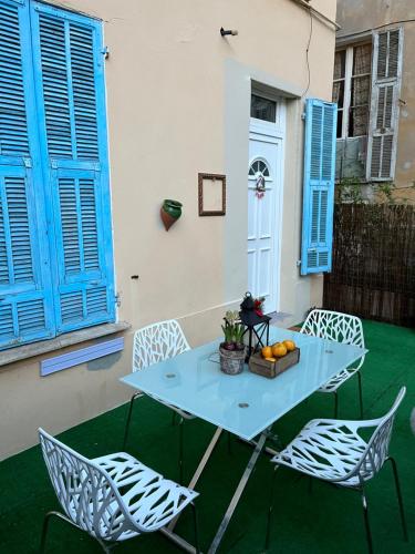 - une table et des chaises avec volets bleus sur la terrasse dans l'établissement Beautiful apartment with terrace Centre Nice, à Nice