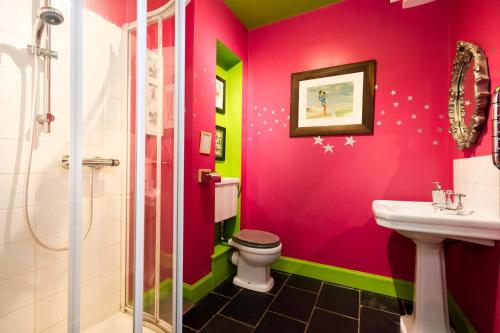 a pink bathroom with a toilet and a sink at Strathendrick House Magnificent property with Garden in Drymen
