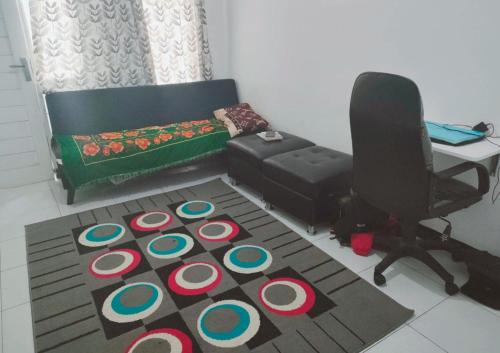 a room with a desk and a chair and a rug at Giri Home & Travel in Ciwidey
