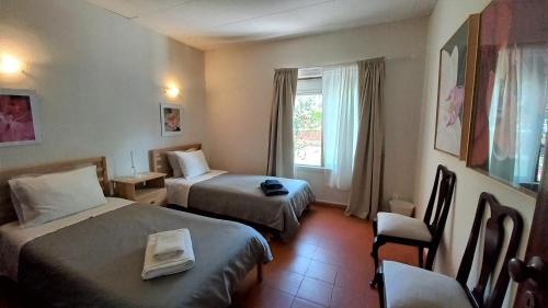 a hotel room with two beds and a window at Estrela do Litoral Beach House in Costa da Caparica