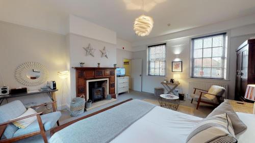 a bedroom with a large bed and a fireplace at Titchwell Manor Hotel in Titchwell