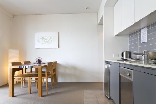 a kitchen with a table and chairs in a room at Cairns Private Apartments in Cairns
