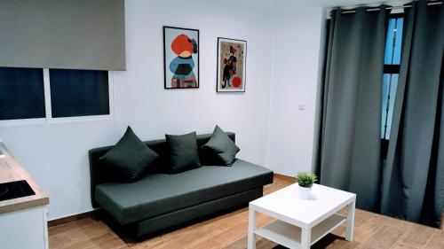 a living room with a couch and a table at Apartamento Ciempozuelos II, cerca del Parque Warner y Madrid in Ciempozuelos