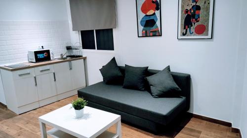 a living room with a couch and a table at Apartamento Ciempozuelos II, cerca del Parque Warner y Madrid in Ciempozuelos