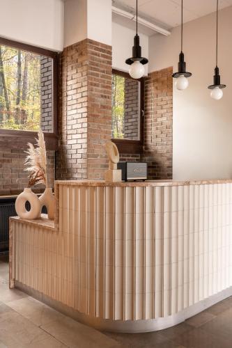 a lobby with a wooden reception counter with windows at Forest Hotel in Kraków