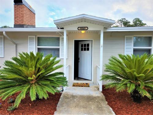 a white house with palm trees in front of it at Comfortable 2bed1bath Unit Sleeps 4 Close To Town Center Downtown Beach Mayo Clinic in Jacksonville