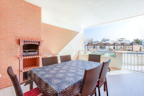 a table and chairs on a balcony with a fireplace at Arco-Iris in Lagos