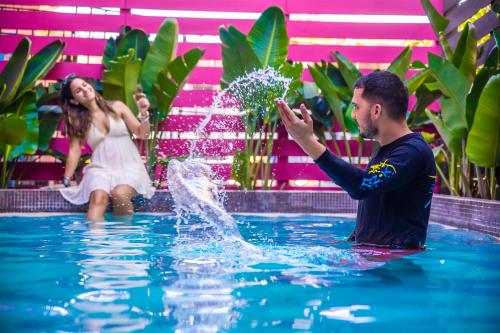 un hombre y una mujer jugando en el agua en una piscina en La Chalé Parguera, en Lajas