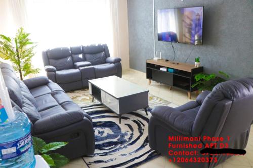 a living room with two couches and a table at Milimani Furnished Apartments in Nakuru
