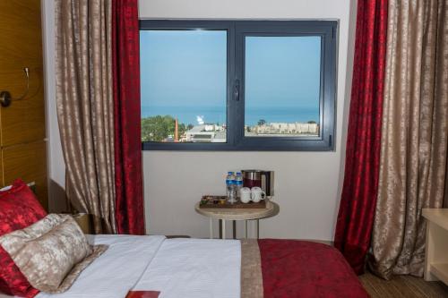 トラブゾンにあるKuhla Hotelのベッドルーム1室(ベッド1台、窓、テーブル付)