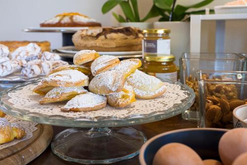 a plate of powdered donuts on a table with other pastries at Nèroli Bio Relais in Catania