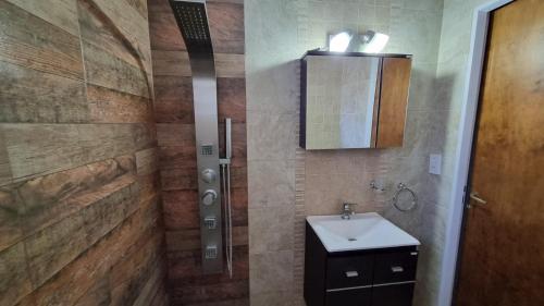 y baño con lavabo y ducha. en Hospedaje "LUZ" en Olavarría