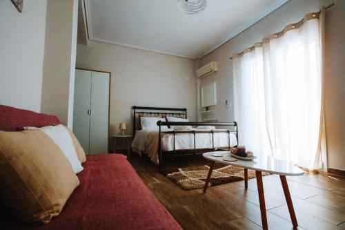 una sala de estar con una cama y una mesa en 3 Bros Studio, en Chalkida