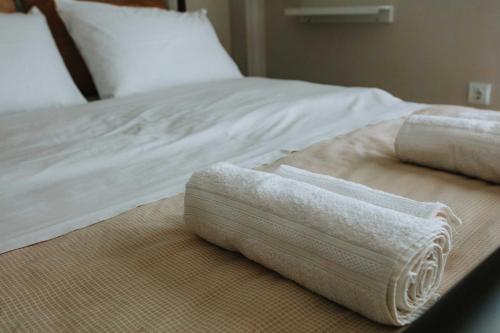 dwa białe ręczniki siedzą na łóżku w obiekcie 3 Bros Studio w Chalkidzie