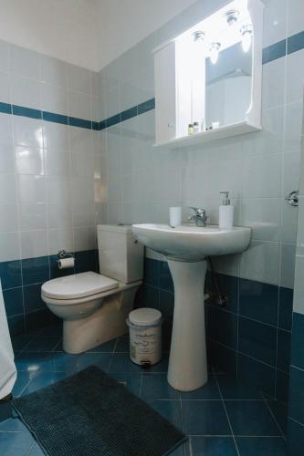 Un baño con lavabo, inodoro y espejo. en 3 Bros Studio, en Chalkida