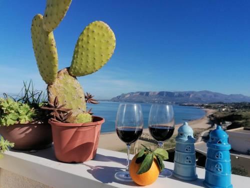 een tafel met twee glazen wijn en cactus bij Appartamento Il Gabbiano in Balestrate