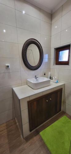 a bathroom with a sink and a mirror at Rock House Villa in Drama