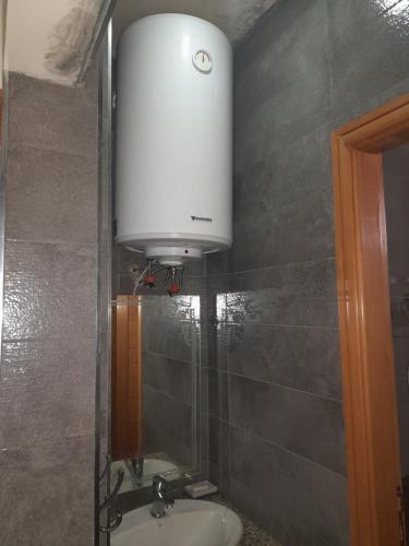 een badkamer met een wastafel en een watertank bij Appartement ennasr49 in Khenifra