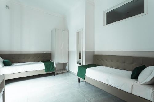 a bedroom with two beds and a flat screen tv at Vaticano Luxury Guest House in Rome