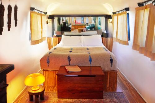 um quarto com uma cama e uma mesa com um candeeiro amarelo em Desert Pearl ⁠— Quick Drive from Big Bend em Terlingua