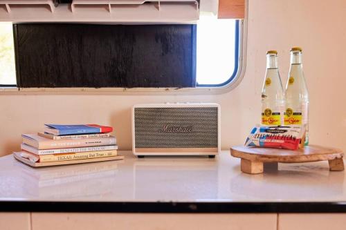 a counter with two bottles of beer and books at Desert Pearl ⁠— Quick Drive from Big Bend in Terlingua