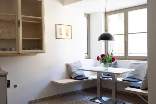 una sala de estar con una mesa blanca y un jarrón de flores en DOMUS FABER, en Merano