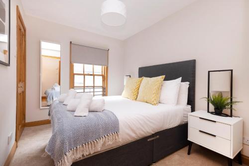 a bedroom with a large bed and a white dresser at JOIVY Bright and Cosy Flat near The Scotland Gallery in Edinburgh