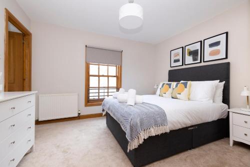 a bedroom with a large bed and a window at JOIVY Bright and Cosy Flat near The Scotland Gallery in Edinburgh