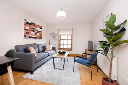 a living room with a couch and a table at JOIVY Bright and Cosy Flat near The Scotland Gallery in Edinburgh