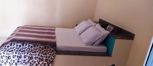 a small bed in a corner of a room at Hotel & Motel ap Aparecida de Goiânia in Aparecida de Goiania