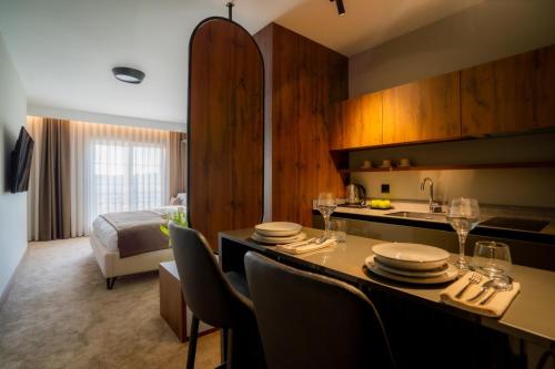 a hotel room with a kitchen and a table with chairs at Downtown Apartments in Pristina