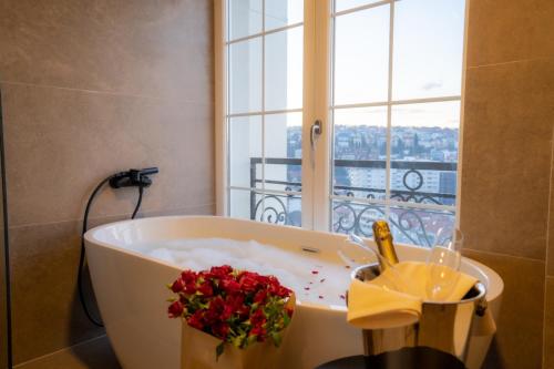 a bath tub with flowers in a bathroom with a window at Downtown Apartments in Pristina