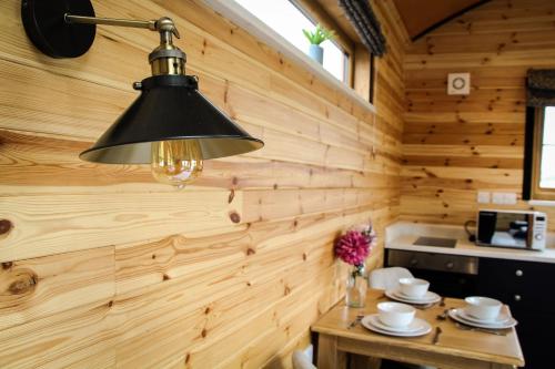una lámpara negra colgada sobre una pared de madera en una cocina en Lily en Rhayader