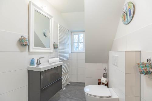 a white bathroom with a toilet and a sink at Lieblingsplatz in Sankt Peter-Ording
