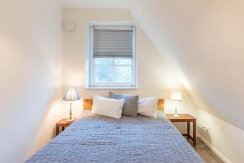 een slaapkamer met een bed met een blauwe sprei en een raam bij Lieblingsplatz in Sankt Peter-Ording