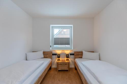 2 Betten in einem Zimmer mit Fenster in der Unterkunft Hooge in Hattstedt