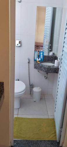a bathroom with a sink and a toilet and a mirror at Hotel & Motel ap Aparecida de Goiânia in Aparecida de Goiania