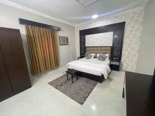 a bedroom with a large bed and a large window at Admire Apart Hotel - 1 in Abu Arish