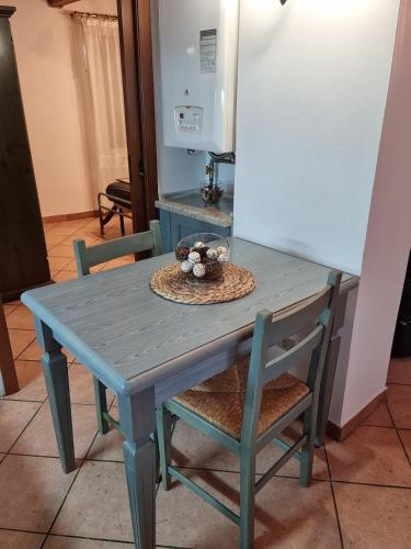 a blue table and chairs with a bowl of flowers on it at L'insolito posto in Nus