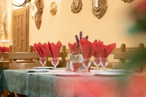- une table avec des serviettes rouges et des verres à vin dans l'établissement Pensiunea Vanatorul, à Băile Tuşnad