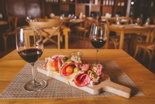 a plate of food and two glasses of wine on a table at Bemar Carmelo Hotel in Carmelo