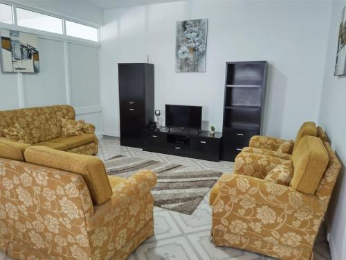 a living room with two couches and a tv at Rua de Baixo Apartments in Calheta