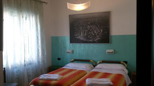 two twin beds in a room with a window at Hotel Paradise in Bruzolo