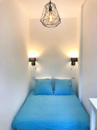 - une chambre avec un lit bleu et 2 oreillers bleus dans l'établissement Homelivia, Votre Appartement ideal pour découvrir Nice, à Nice