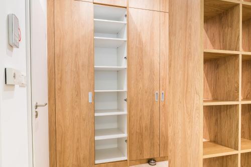 a wardrobe with wooden doors and shelves in a room at City Castle Apartments Free Parking in Bratislava