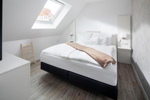 um quarto com uma grande cama branca e uma janela em Salt and Sea em Norderney