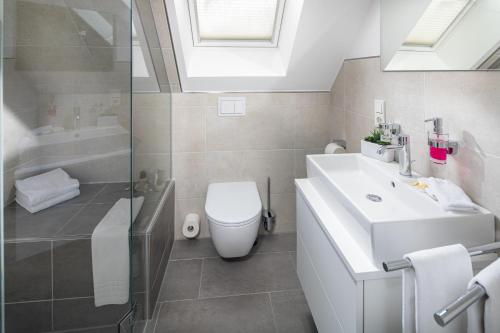 ein Badezimmer mit Waschbecken, Toilette und Dusche in der Unterkunft Salt and Sea in Norderney