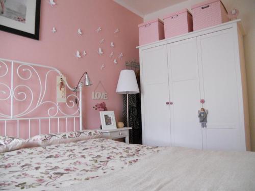 a pink bedroom with a bed and a white cabinet at La casa azzurra in Moneglia