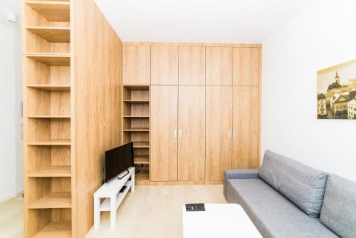 a living room with a couch and wooden cabinets at City Castle Apartments Free Parking in Bratislava